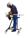 Schweisser mit Schutzhelm und Lederhandschuhen schweisst an der CREA-FIX, Lichtbogen an der Spannstelle sichtbar