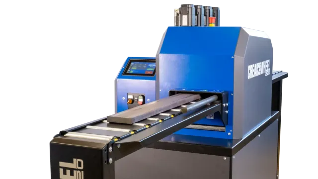 CREA-WHEEL 220 RRM in der Gesamtansicht mit Touch-Bedienpanel, Signalsäule und angesetzter Rollenbahn mit Flachstahl