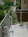 Zwei MS1 stützen ein Edelstahlgeländer auf einer Terrasse während der Montage ab