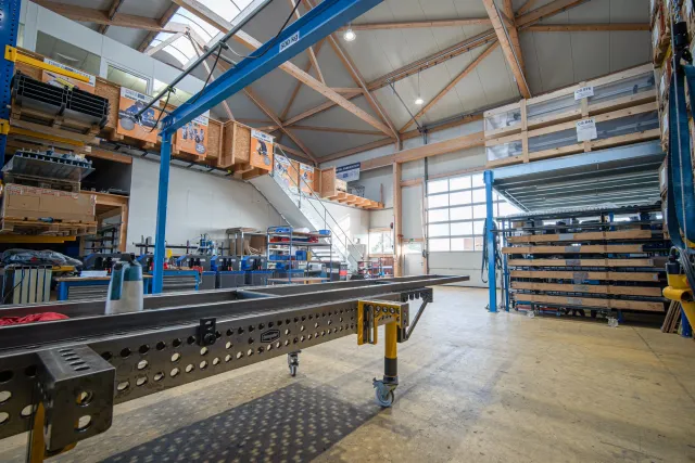 Lochraster-Schweisstisch auf Rollen in der Produktionshalle, dahinter eine Reihe CREA-WHEEL Maschinen