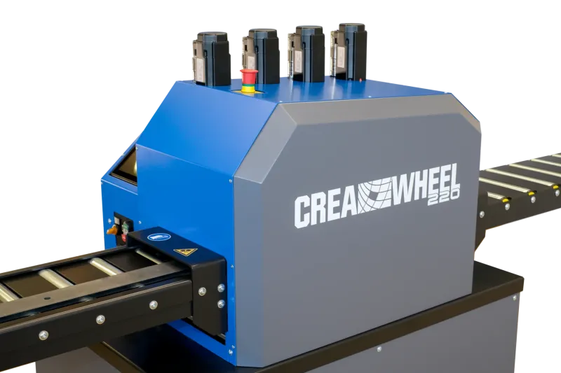 Gehäuse der CREA-WHEEL 220 aus der Nähe, Not-Aus-Pilz und Einlaufabdeckung mit Warnpiktogrammen