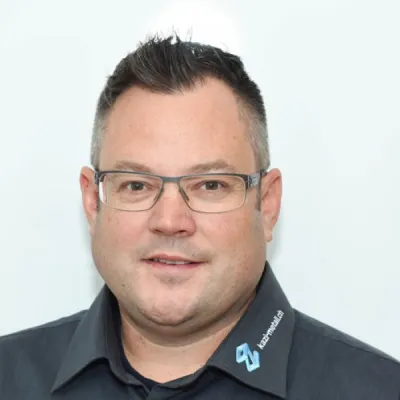 Andreas Fischer, Geschäftsführung der Karl Zimmermann AG, Porträt mit Brille vor hellem Hintergrund